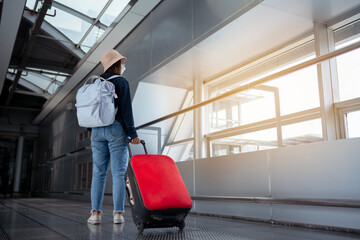 Fototapeta na wymiar Traveler with suitcase in airport concept.Young girl walking with carrying luggage and passenger for tour travel booking ticket flight at international vacation time in holiday rest and relaxation..