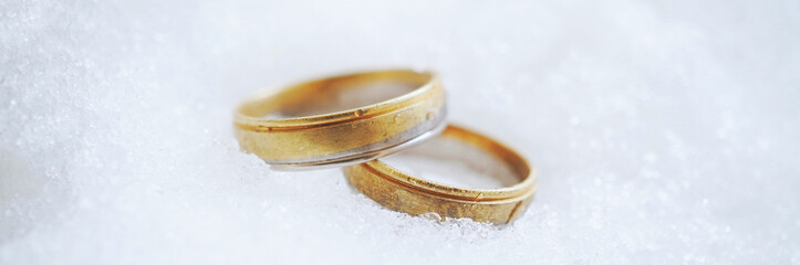 Gold wedding rings jewelry on snow banner design. Winter wedding invitation.