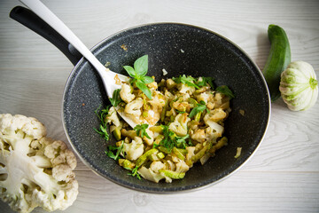cauliflower fried with zucchini and vegetables in a pan