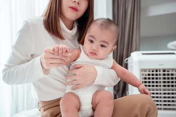 Lover of mother carrying newborn baby or cute little lying on a white bed at home. Infant child portrait happy concept, Healthy childcare in the morning.