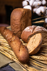 Freshly baked crusty bread and buns with wheat ears top view