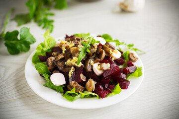 Salad with boiled beets, fried eggplants, herbs and arugula in a plate