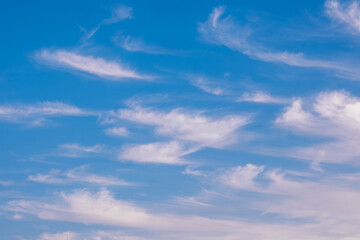 Cirrus white clouds in the blue sky. Bright sky, beautiful horizon, heavenly landscape for background. Calm bright aerial background.