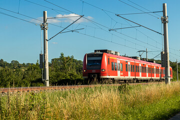 Obraz premium Ein Personenzug auf Gleis mit elektrischer Oberleitung