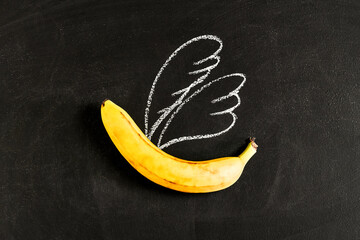 banana with painted wings on a chalkboard