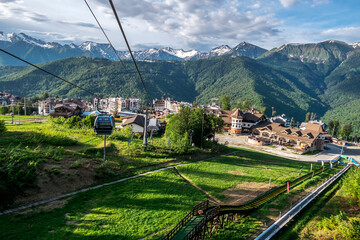 Cable car cabin rises up from Rosa Khutor village to Roza Peak mountain in Sochi resort.