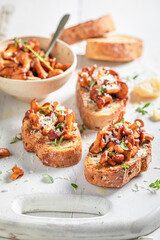 Homemade and tasty toasts with chanterelles, parmesan cheese and herbs.