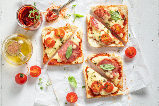 Crunchy and vegetarian toasts with salami, tomato and cheese.