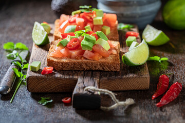 Homemade and tasty toasts with tomatoes, lime and coriander.