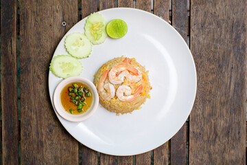Fried rice with shrimp on the wooden table.