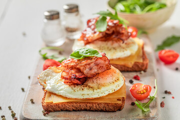 Tasty and fresh toasts with toast, bacon and eggs.