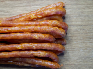 Traditional Polish sausages Kabanos on a wooden surface, macro photo. Kabanos, also known as cabanossi or kabana, is a long, thin, dry sausage usually made of pork which originated in Poland.