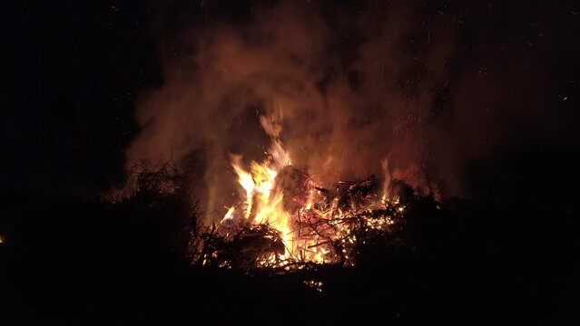 View of blazing bonfire, camera panning up to smoke and sparks, 4k footage