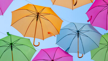 Fototapeta na wymiar Beautiful multicolored umbrellas from a low angle. Summer holiday city scape concept.