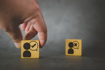 Hand choose man with tick mark icon on wooden cube block, decision making, approval or voting.