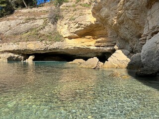 Rocks cave in the sea with clear water. Beautiful paradise secluded beach of Mediterranean coast. 