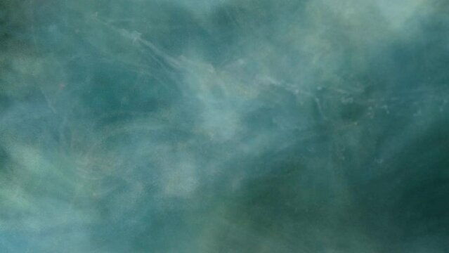 White ink spreading in water on a black background. Colored acrylic cloud abstract smoke background. Glitter fluid motion. 