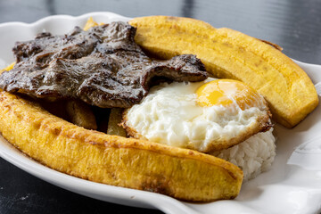 Peruvian food: Bistec to the poor. With egg, fried banana and potatoes. Close up