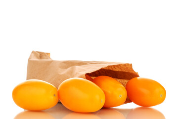 Several ripe yellow tomatoes with a paper bag, close-up, isolated on a white background.