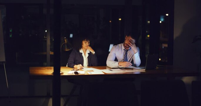 Lawyers arguing and planning a strategy overtime in office at night. Paralegals discussing solution on case. Two stressed businesspeople working late, meeting, talking and reading deadline paperwork.