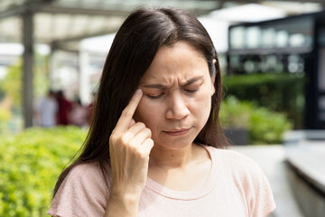 Fototapeta premium Middle-aged woman suffering from headache, early warning sign of stroke, over stress, office syndrome