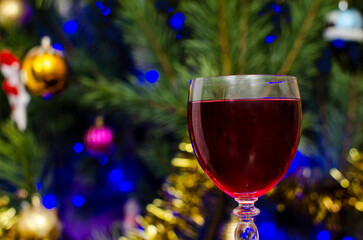 A glass of red wine on the background of a Christmas tree