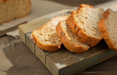 Close-up of sliced rye bread with cereals on a wooden board. Selective focus. Tinting. The concept of healthy eating.
