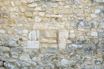 Ancient stonewall with irregular pattern and grungy atmosphere from house in Carpentras, France