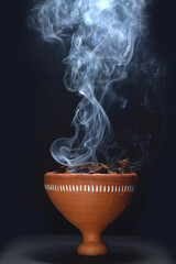Durga puja dhunuchi with smoke isolated on black background.