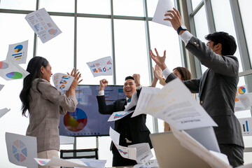 Asian business team celebrate corporate victory together in office, laughing and rejoicing, smiling...