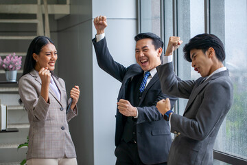 Asian business team celebrate corporate victory together in office, laughing and rejoicing, smiling excited employees colleagues screaming with joy in office. - 516041775