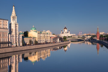 City center skyline with old buildings along river banks reflected in still water, Moscow, Russia