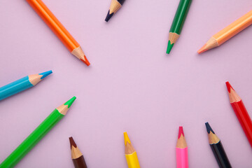 Color pencils on purple background. Close up.