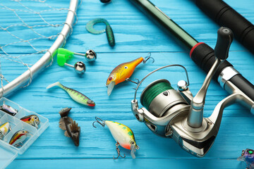 Fishing rods and spinnings in the composition with accessories for fishing on blue background.