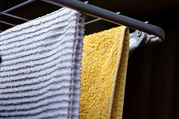 Drying white and yellow towels on the clothes-horse close up shot .