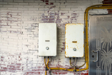 Old and new water gas boilers used at home during cold season with the pipe lining connection into the house.