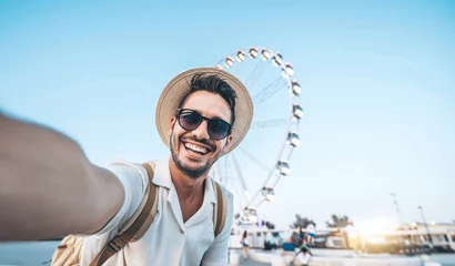 Foto op Canvas Happy tourist taking selfie on summer vacation - Smiling guy looking at camera outside - Millenial taking photo with smart mobile phone - Focus on eye © Davide Angelini