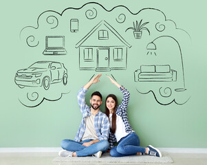 Young couple dreaming about their new house and car near green wall in room