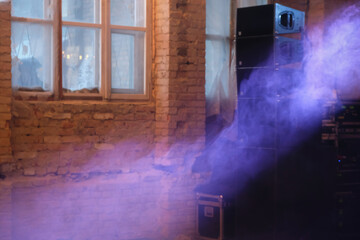 Purple smoky light in an abandoned industrial area. Brick walls. Disco party. Blurred image.