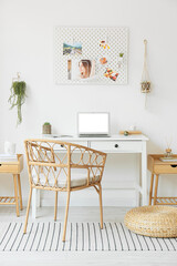 Interior of light office with workplace, laptop and pegboard
