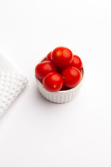 close up shot of cherry tomatoes in container on white background with copy space