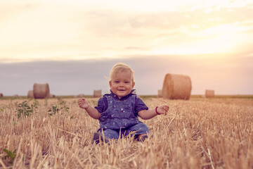 happy and smiling  baby girl on field of wheat