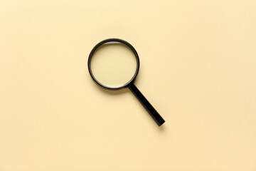 Magnifying glass on beige background