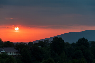 Sunset over a forest landscape. Beautiful sunset over the forest. Picturesque sunset landscape. Red sunset panorama. Ukraine, July 2022.