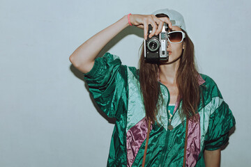 Cool teenager. Fashionable girl in colorful trendy jacket and vintage retro sunglasses with camera...