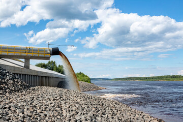 Spillway into the river from an industrial complex. - obrazy, fototapety, plakaty