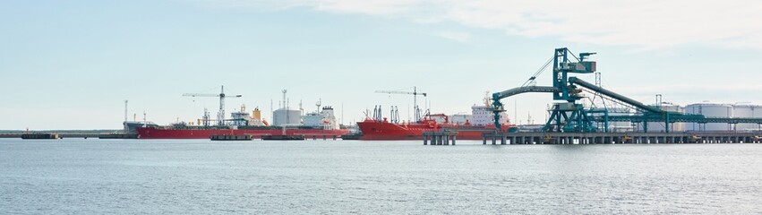Ship loading in cargo port terminal. Cranes, grain elevator. Ventspils, Latvia, Baltic sea. Freight...