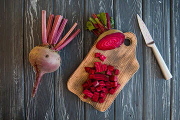 Red beets on a cutting board with a knife