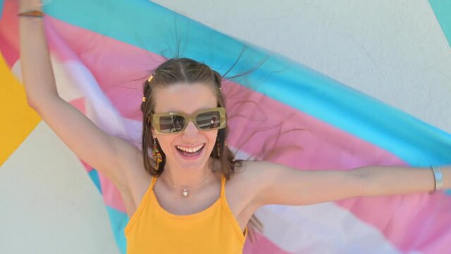 The young woman has fun with a trans flag.