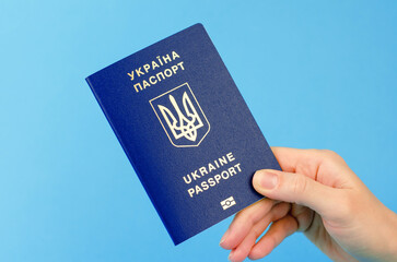 Passport of a citizen of Ukraine in a female hand close-up. Inscription in Ukrainian Passport of Ukraine